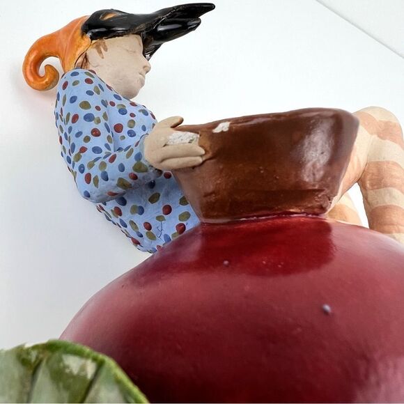 CARRIANNE L HENDRICKSON woman with beak hat sitting on apple sculpture 2… - Picture 14 of 16